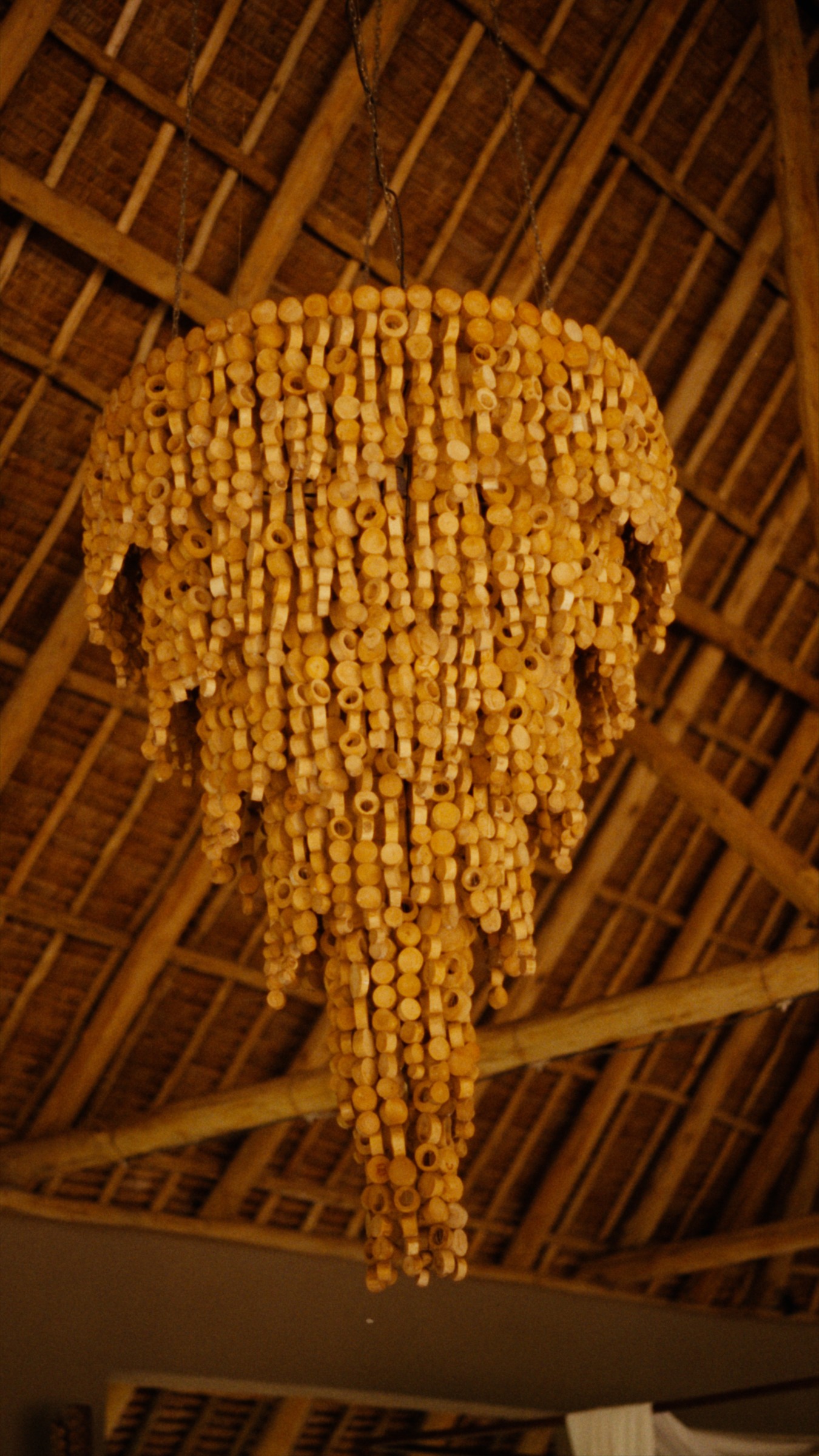 A sculptural chandelier beneath the thatched roof.
